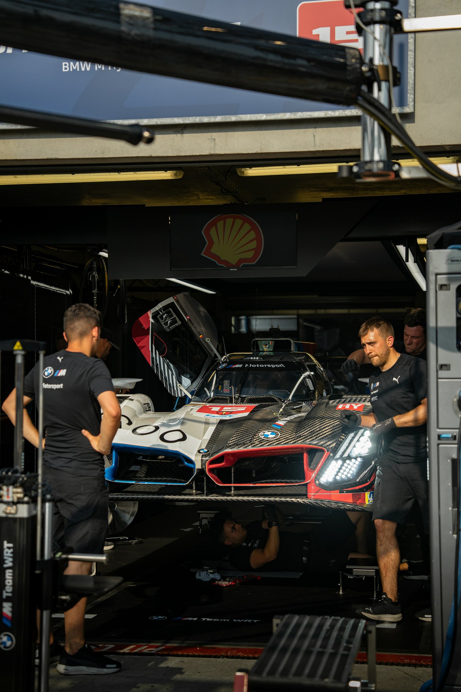 Mecánicos trabajando en un coche de carreras dentro del box