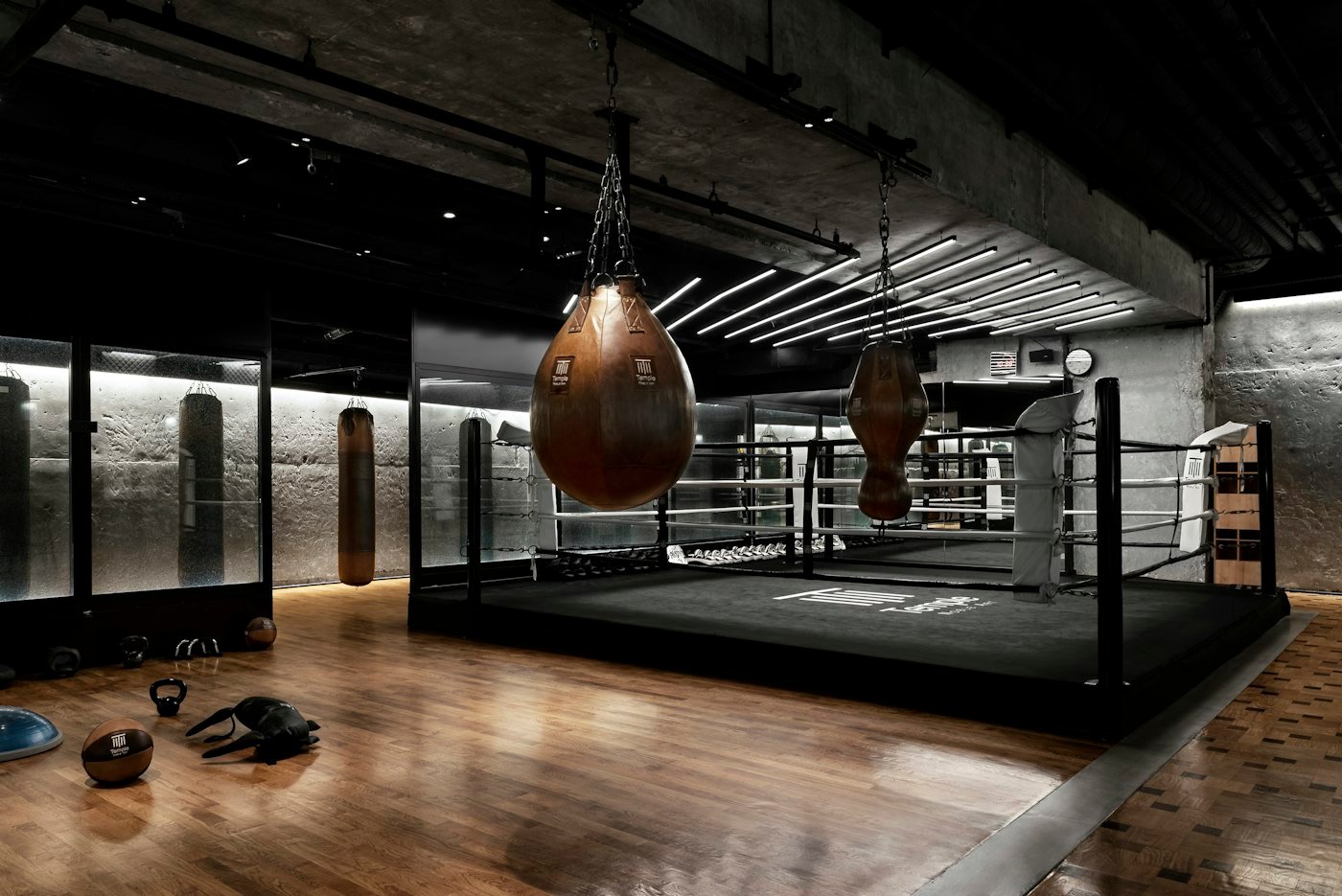 Ring de boxeo con guantes colgados en una nave