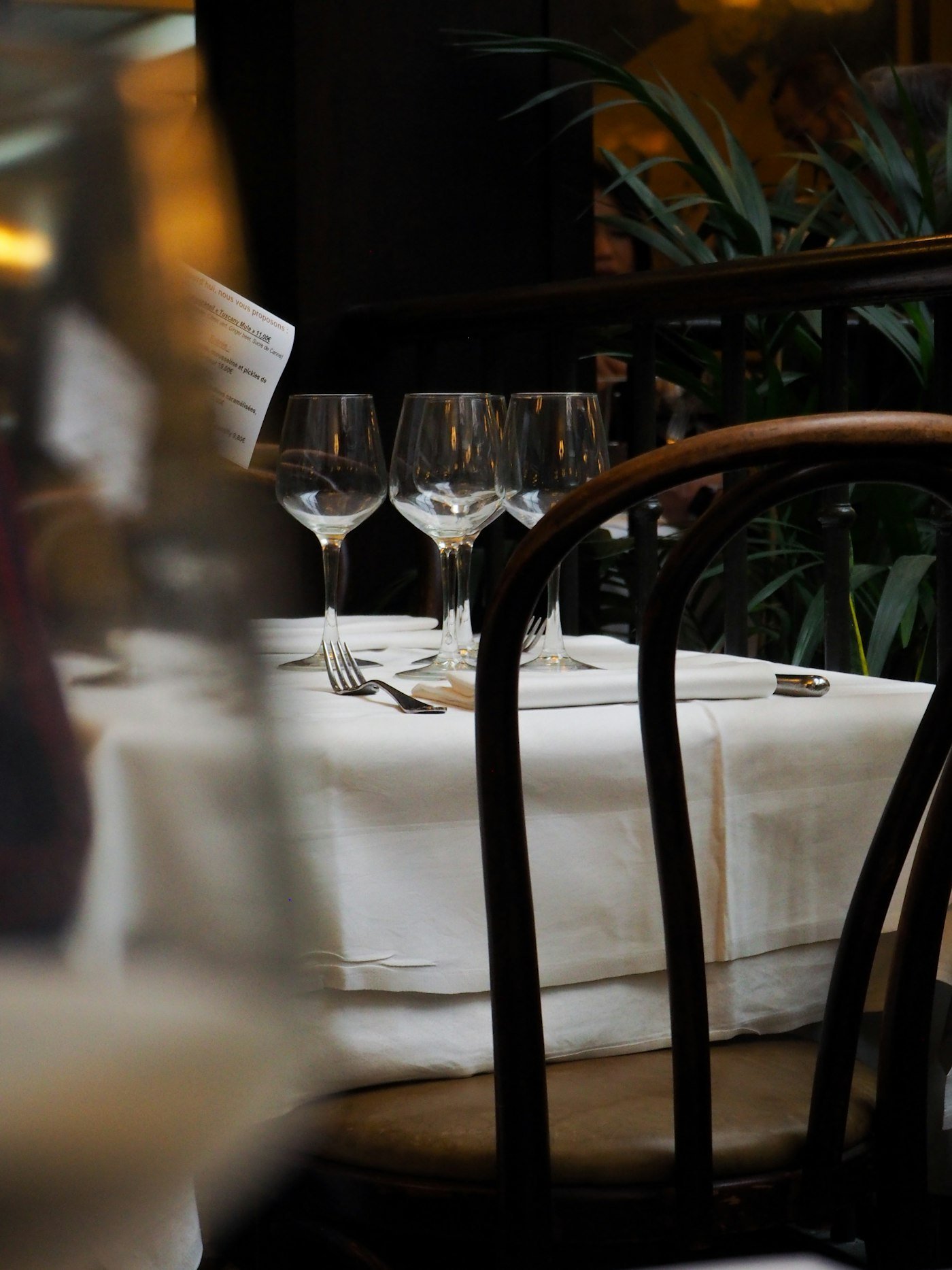 Mesa de restaurante puesta con copas de vino y cubiertos
