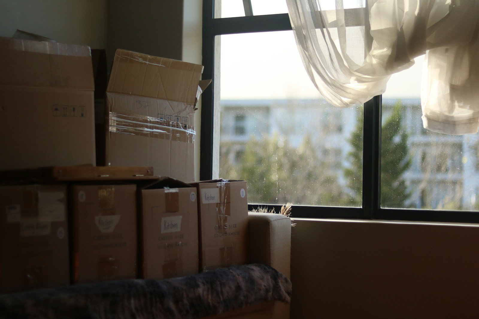 Habitación con cajas junto a la ventana